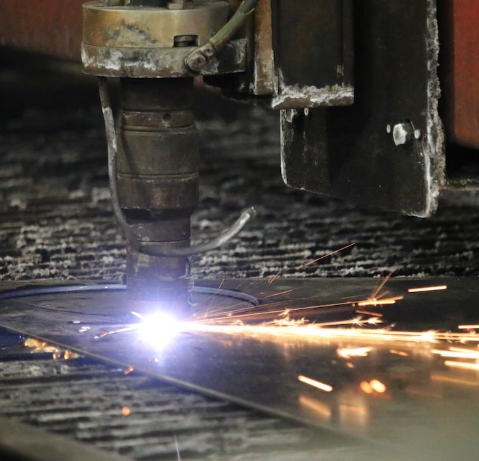 A plasma cutter cutting a sheet of metal