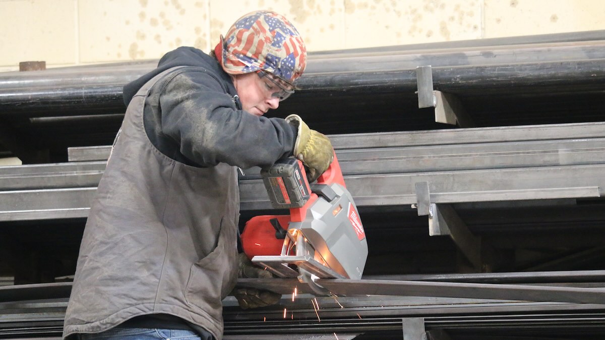 A worker cutting metal